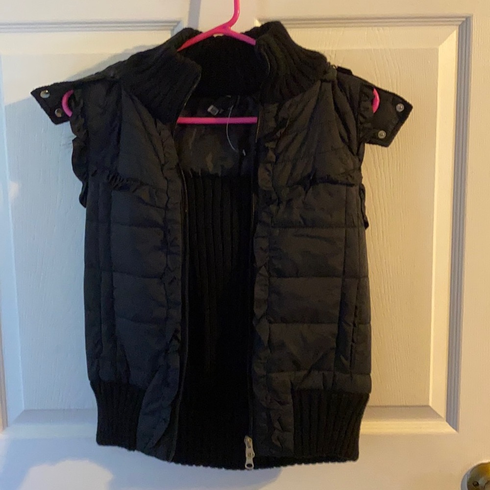 Take out black sleeveless jacket with hood.